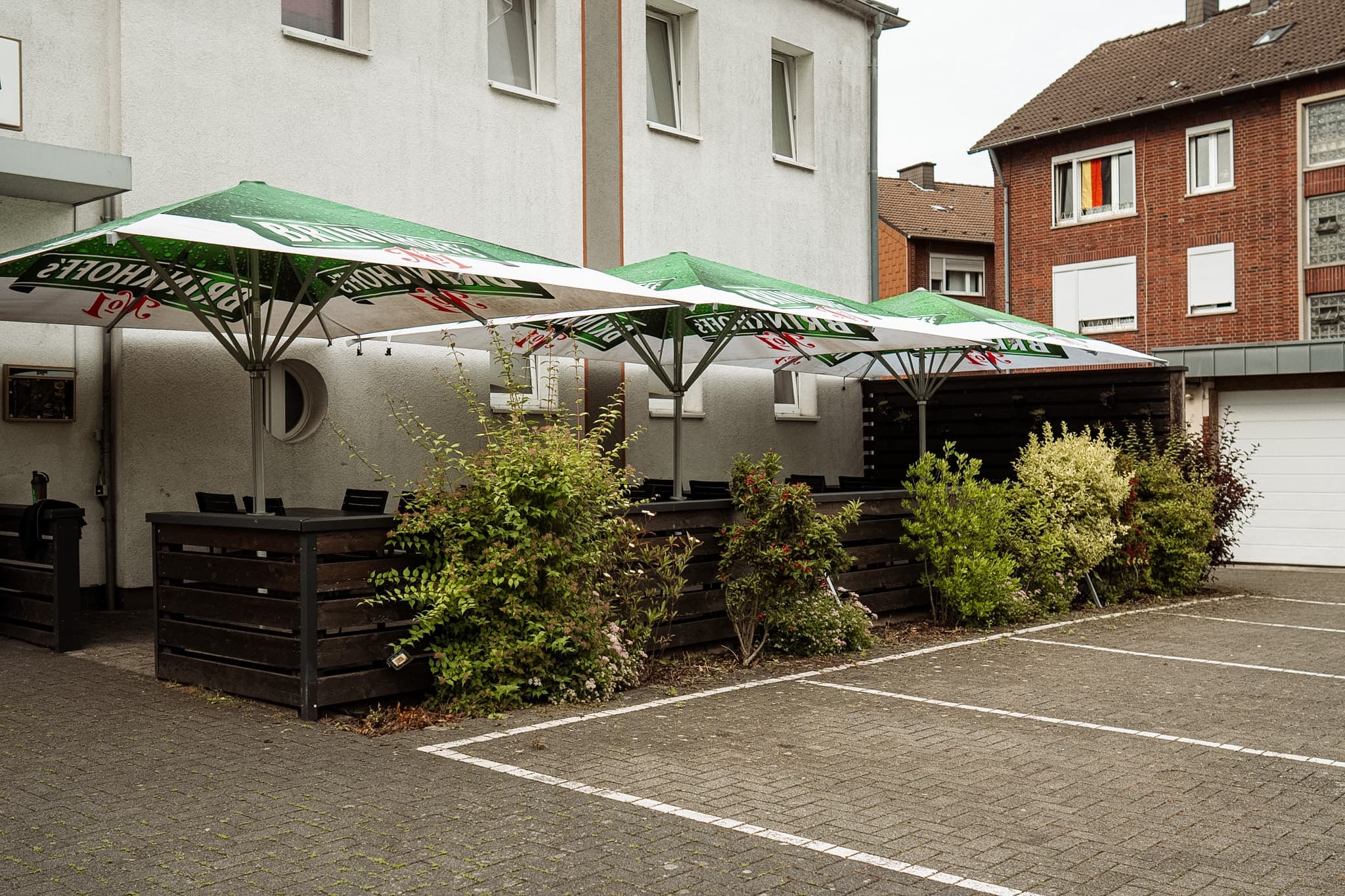 Sommergarten der Lightning Sportsbar Lüdinghausen mit überdachten Sitzplätzen unter Schirmen